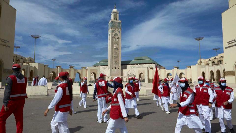 Young Moroccan Red Crescent volunteer girls wear their masks on their faces preparing to leave after helping the faithful to uphold social distancing at the Grand Hassan II Mosque in Casablanca, Morocco, Friday, Oct. 16, 2020 . In Morocco today, around 10,000 mosques have opened their doors for the faithful to perform the Friday prayer which has been banned due to the COVID pandemic. For the first time since the outbreak of coronavirus in March, Morocco has allowed mosques to reopen for Friday prayers. (AP Photo / Abdeljalil Bounhar)
