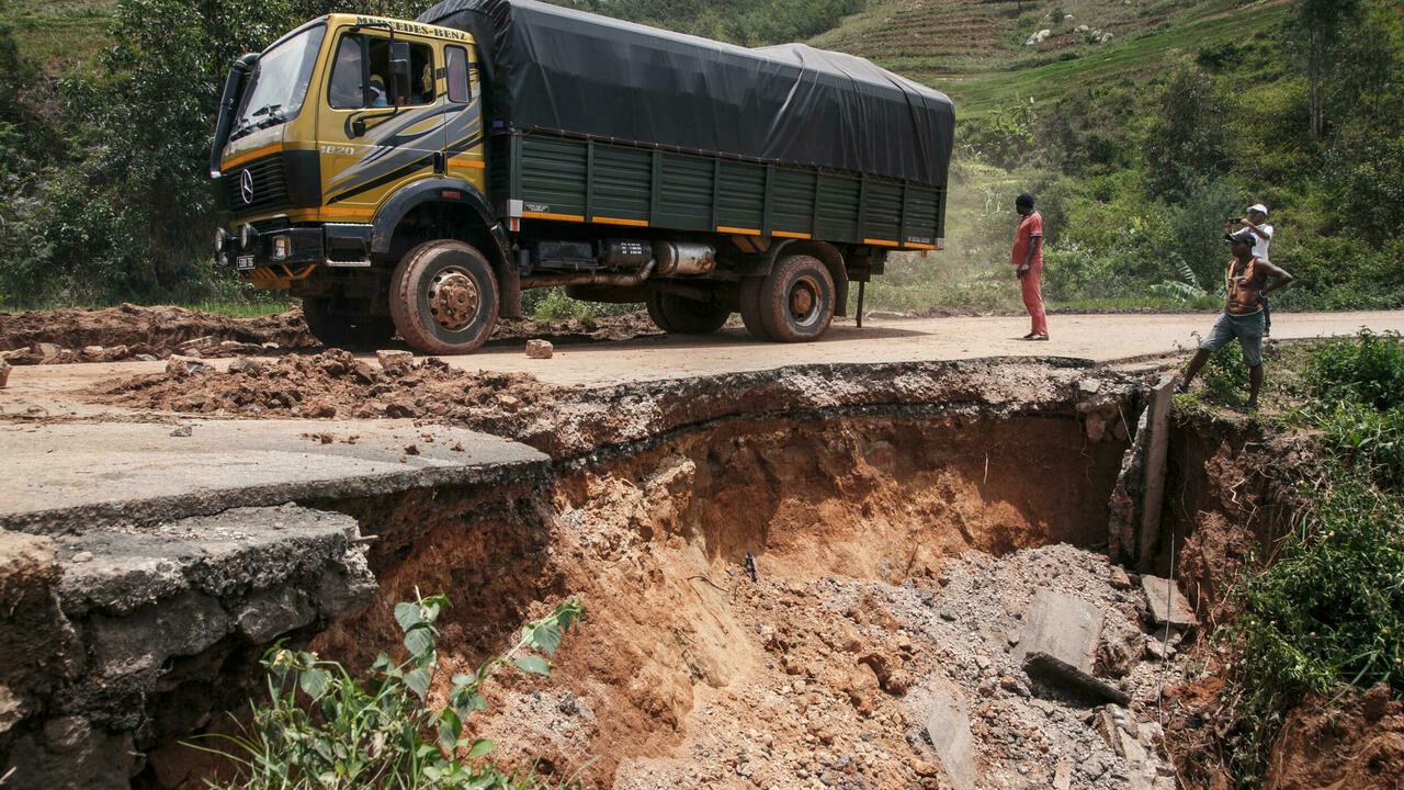 Residents look at the partially collapsed RN25 road in Ranomafana on February 7, 2022 following the passage of cyclone Batsirai. – Cyclone Batsirai swept out of Madagascar on Monday after killing 20 people, displacing 55,000 and devastating the drought-hit island’s agricultural heartland, leading the UN to warn of a worsening humanitarian crisis. (Photo by RIJASOLO / AFP)