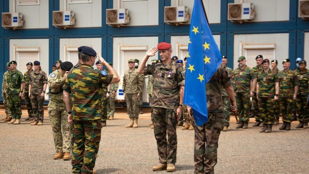 French general Jacques Langlade de Montgros (C) passes the command of the European union training mission (EUTM) in Central african Republic to the Belgian general Jacky Cabo (L) during a handover ceremony in Bangui on February 3, 2022. – The European Union said Thursday it would resume its military training mission in the Central African Republic providing the country’s soldiers stop working for the Russian paramilitary group Wagner. (Photo by Carol VALADE / AFP)
