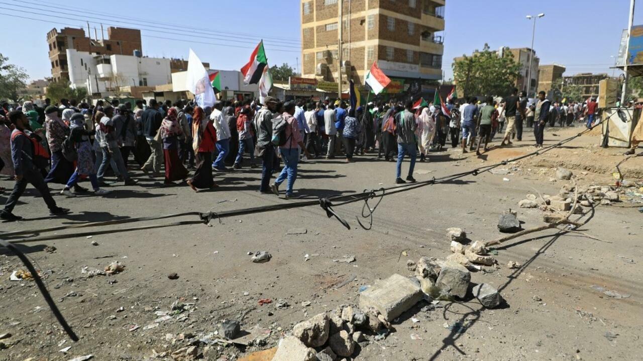 Sudanese protesters wave the national flag during a demonstration calling for civilian rule and demanding justice for those killed in crackdowns in the capital Khartoum on January 24, 2022. (Photo by AFP)
