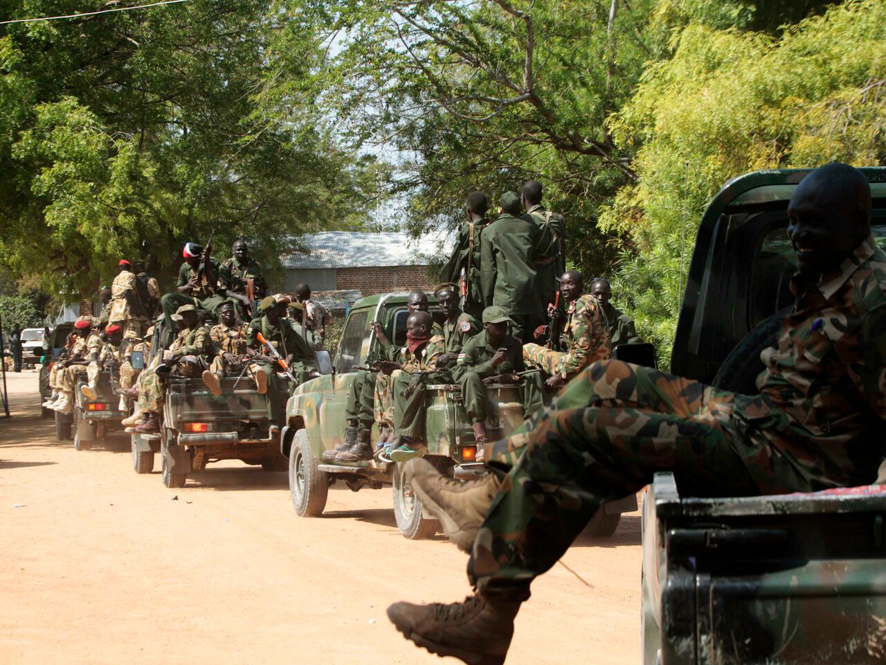 South Sudan army soldiers hold their weapons as they ride on a truck in Bor, 180 km (108 miles) northwest from capital Juba December 25, 2013. South Sudanese troops have retaken the flashpoint town of Bor in Jonglei state, a week after the town fell to rebels loyal to rebel leader Riek Machar. REUTERS/James Akena (SOUTH SUDAN – Tags: POLITICS CIVIL UNREST MILITARY)