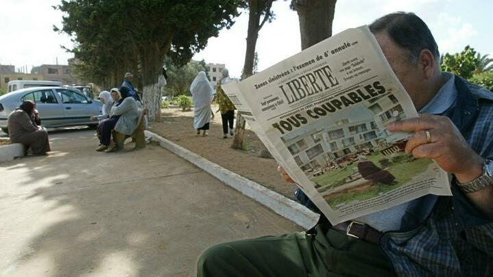 An Algerian reads the 26 May 2003 « Liberte » newspaper titled » All guilty » 26 May 2003, at the entrance of El Alia cemetery in Algiers. The Algerian government scrambled Monday to dispel criticiem it has dragged its heels in helping victims of last week’s deadly quake, as Islamic radicals took advantage of the widespread anger towards the authorities and stepped in to fill the void. AFP PHOTO/PHILIPPE DESMAZES (Photo by PHILIPPE DESMAZES / AFP)