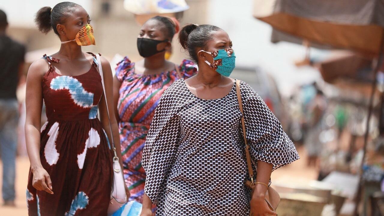 Women wear masks made with African textiles as they walk through the Adidogomé Assiyeye market in Lome on April 17, 2020. – Togolese President Faure Gnassingbé on Wednesday evening declared a « state of health emergency » to prevent the spread of the coronavirus, which has already killed two people in the country for 36 cases identified and has ordered a remission of sentence for more than 1,000 prisoners. (Photo by AFP)