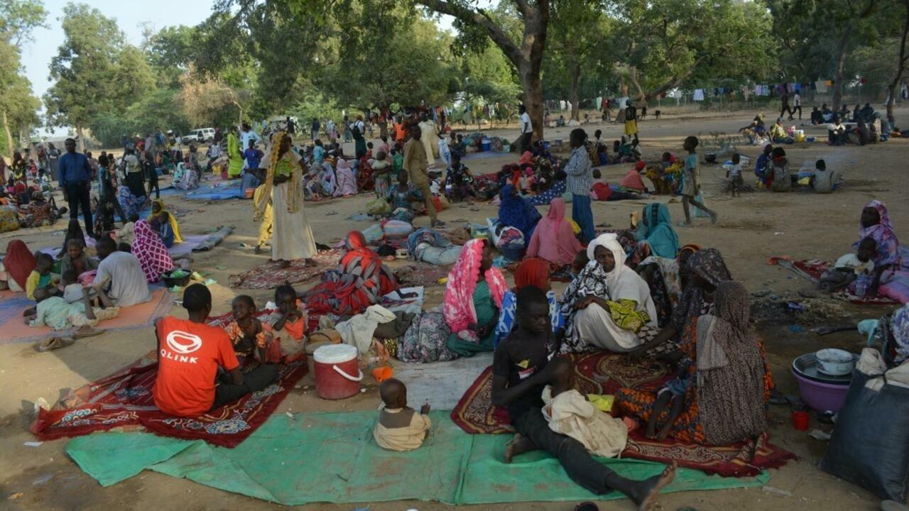 Cameronian refugees who fled the violence that broke out in the border village of Ouloumsa on Sunday in a dispute between herders, fishermen and farmers over dwindling water resources gather in Ndjamena on December 10, 2021. – More than 30,000 people in northern Cameroon have fled to Chad after ethnic clashes erupted at the weekend, claiming at least 22 lives, the UN’s refugee agency said on Friday. (Photo by Djimet WICHE / AFP)