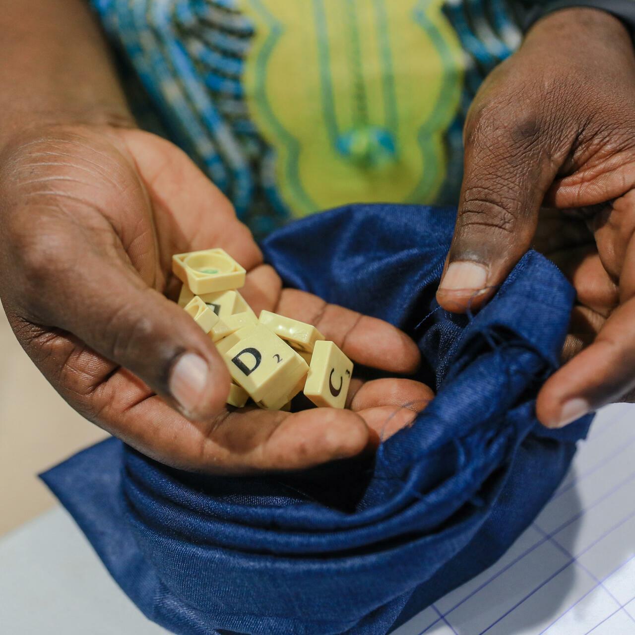 A judge holds a bag containing the letter tiles used to play scrabble during the 6th edition of the African Francophone Scrabble Championship in Yaounde on May 12, 2022. (Photo by Daniel Beloumou Olomo / AFP)