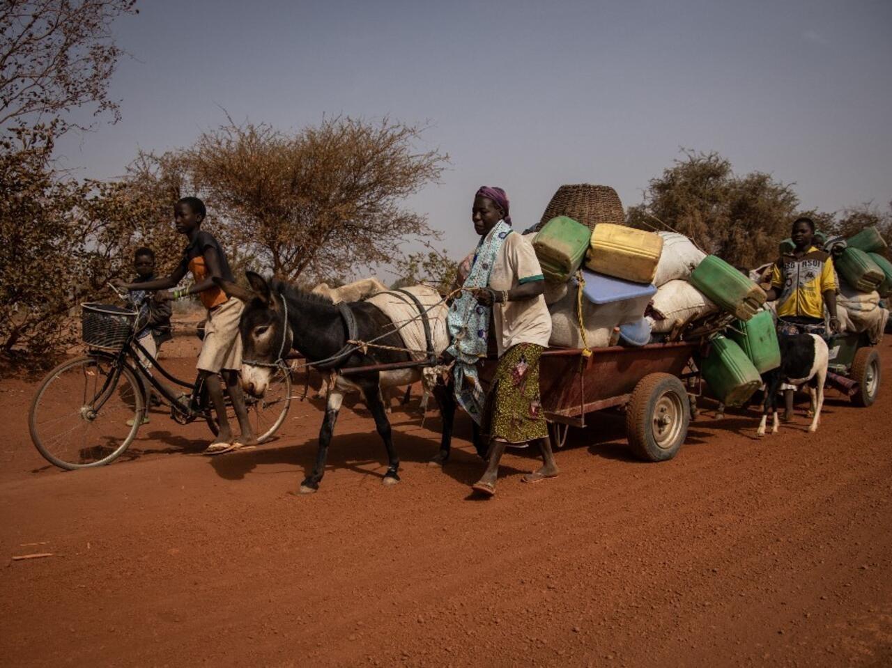 People with their belongings piled on a makeshift trailer pulled by a donkey flee their villages, on the road from Barsalogho to Kaya on January 27, 2020. – Barsalogho is a small town in northern Burkina Faso that hosts 10,000 displaced persons and refugees fleeing the resulting jihadist and inter-community violence. Burkina Faso, which borders Mali and Niger, is facing jihadist attacks, which have killed more than 750 people since 2015. Under-equipped and poorly trained law enforcement agencies in Burkina Faso are unable to stop the spiral of violence. According to the United Nations, jihadist attacks in Mali, Niger and Burkina have resulted in 4,000 deaths in 2019. (Photo by OLYMPIA DE MAISMONT / AFP)