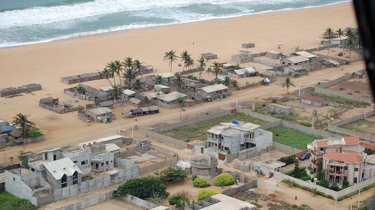 TO GO WITH AFP STORY by Fiacre VIDJINGNINOU- This aerial photo shows a view of Togbin beach and the dirt road dubbed « road of sins » on October 21, 2009 near Ouidah. The thin strip of land, some 30km in length stretching between the Atlantic Ocean and Cotonou Lagoon, has become the focus of a battle between developers, the ministry of tourism and locals. A 200 million euro investment project aimed at building luxury hotels and casinos is pitted against the protection of the region’s colonial slave past and fishing villages dotted along the coastline. AFP PHOTO / Fiacre VIDJINGNINOU